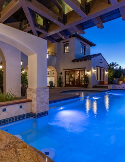 A swimming pool in a home at dusk.