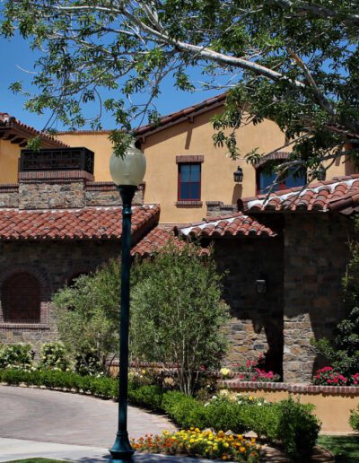 A mediterranean style home with a driveway and trees.