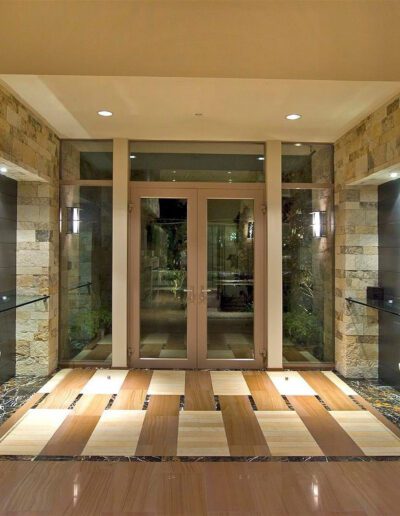 An entryway with a stone floor and light fixtures.
