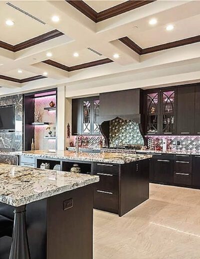 A large kitchen with marble counter tops and bar stools.