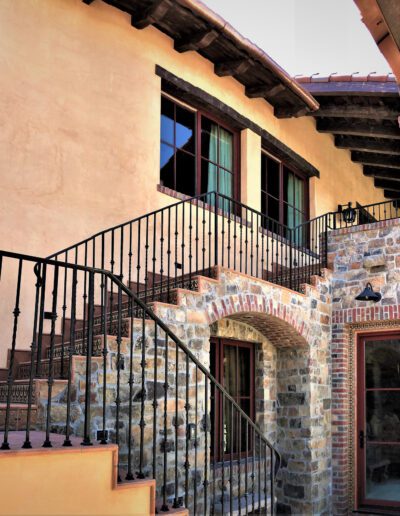A house with stairs and wrought iron railings.