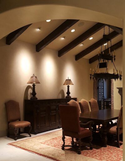 A dining room with a large table and chairs.